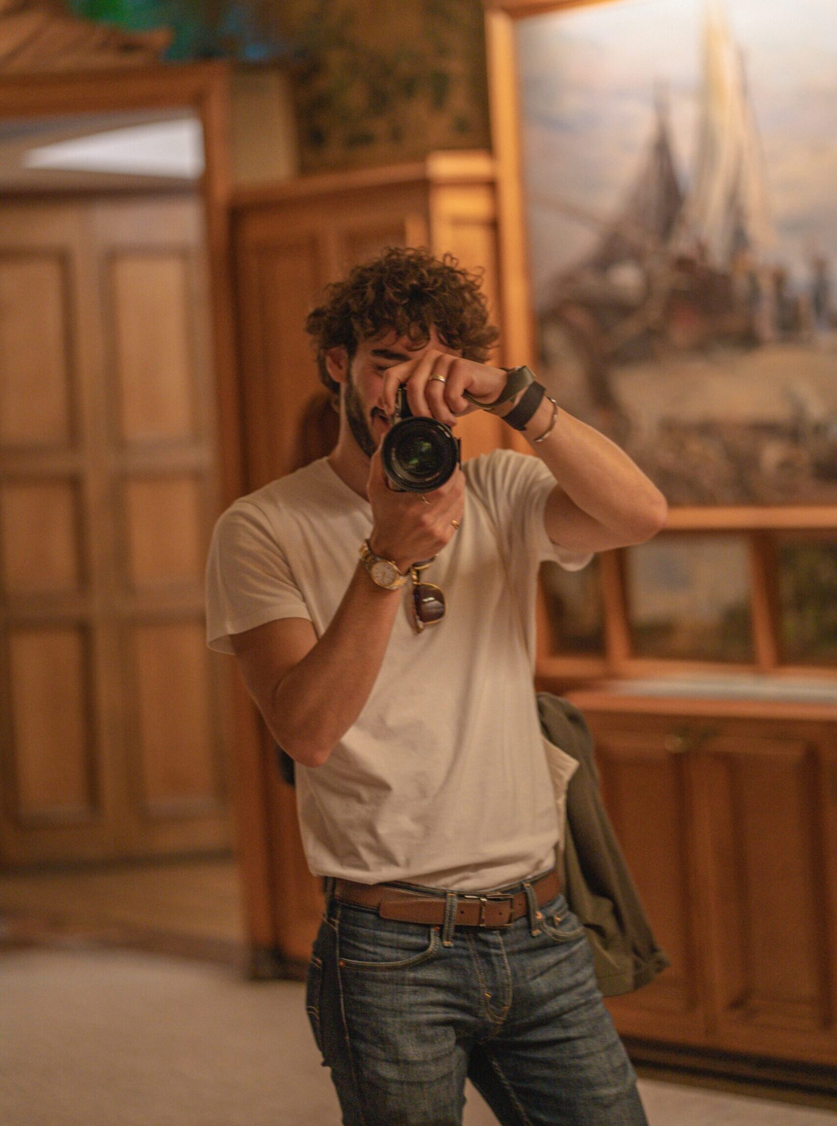 Self-portrait in a mirror with camera, wearing jeans and a white t-shirt